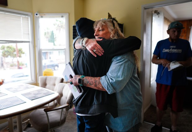 Heather Newhart offers a hug for support to Vincent Oliveri, 33, who has been living at the home for the past 4 months. Many of her clients are struggling with substance abuse or have recently been released from prison. (Nelvin C. Cepeda / The San Diego Union-Tribune)