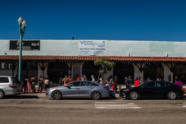 People wait in line at a food distribution with food from Feeding San Diego at  Iglesia Casa de Alabanza in City Heights  on March 26, 2026. (Ariana Drehsler / For The San Diego Union-Tribune)