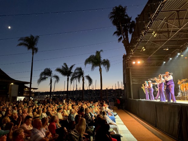 Saxophonist Dave Koz, center, is shown performing at Humphreys Concerts by the Bay in 2025 with his Summer Horns band. "Humphreys is one of the most beautiful spots in the world to do a concert, and it's uniquely San Diego," he says. (Bobbi Brieske)