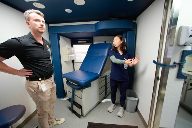 Eileen Kim, a second-year medical student from UC San Diego, shows one of the exam rooms in the Mobile Health Clinic to Michael Kennedy of the County of San Diego. (Nelvin C. Cepeda / The San Diego Union-Tribune)