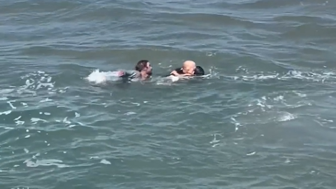 A California swimming coach rescues a father and daughter struggling in rip currents at a local beach.