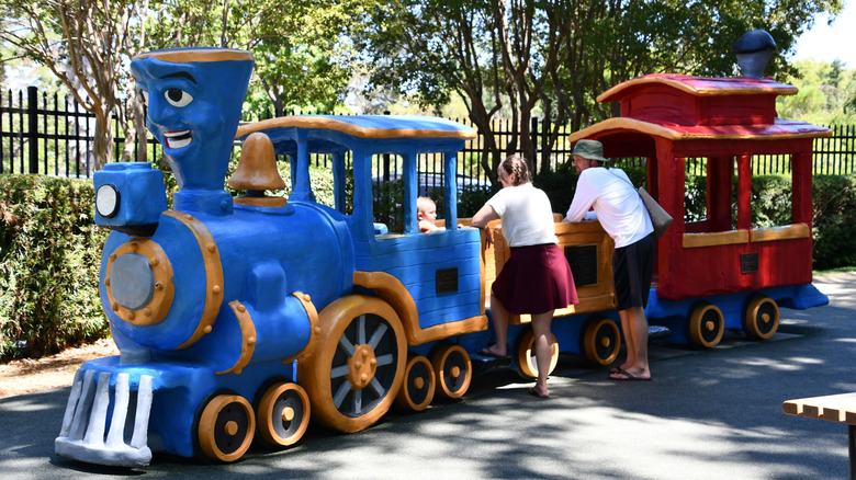 Parents supervise their kids playing on a Little Engine That Could playset