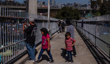 People take photos from the bridge in Barrio Logan on Chicano Park Day on April 22, 2023.