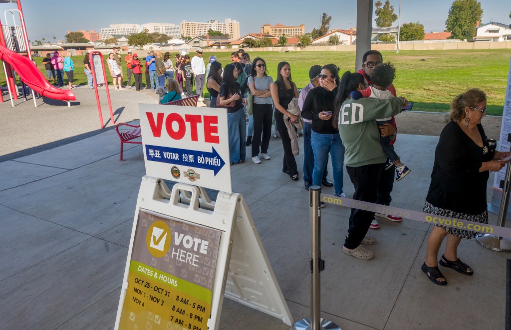 Voters standing in long lines to cast their ballots at a polling station.