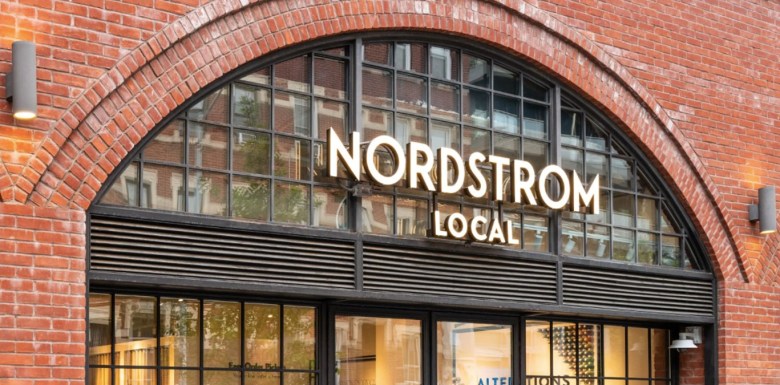 A brick storefront surrounds a glass window and front doors with the words "Nordstrom Local" on the facade.