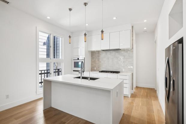 Modern, white kitchen with high-end appliances.