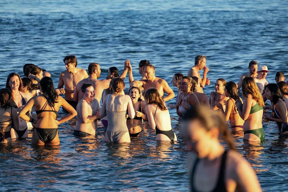 Members of the Salty Dogs Club gather in the water during their Friday morning plunge. The group has grown into a popular social gathering since it was formed in 2024. (Jana Ašenbrennerová/For the S.F. Chronicle)