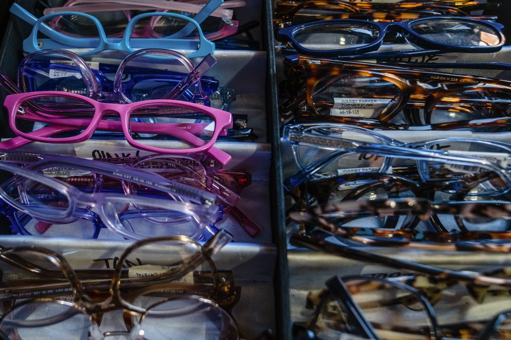 A close-up of an assortment of glasses in various colors that are stacked on top of each other on an open case.