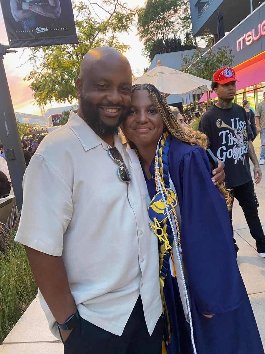 Pastor Montre Everett poses for a photo with his daughter Monae Everett at her high school graduation from Inderkum High in 2024.