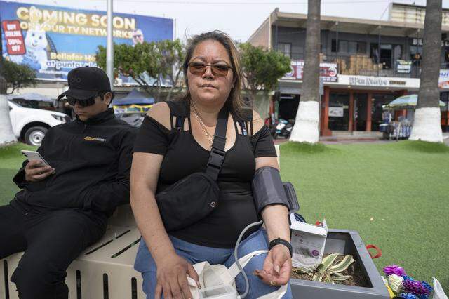 Maria de Jesus Estrada Juarez checks her blood pressure in Tijuana, Mexico, on Monday, March 30, 2026, just before walking across the border to the United States at the San Ysidro pedestrian crossing.