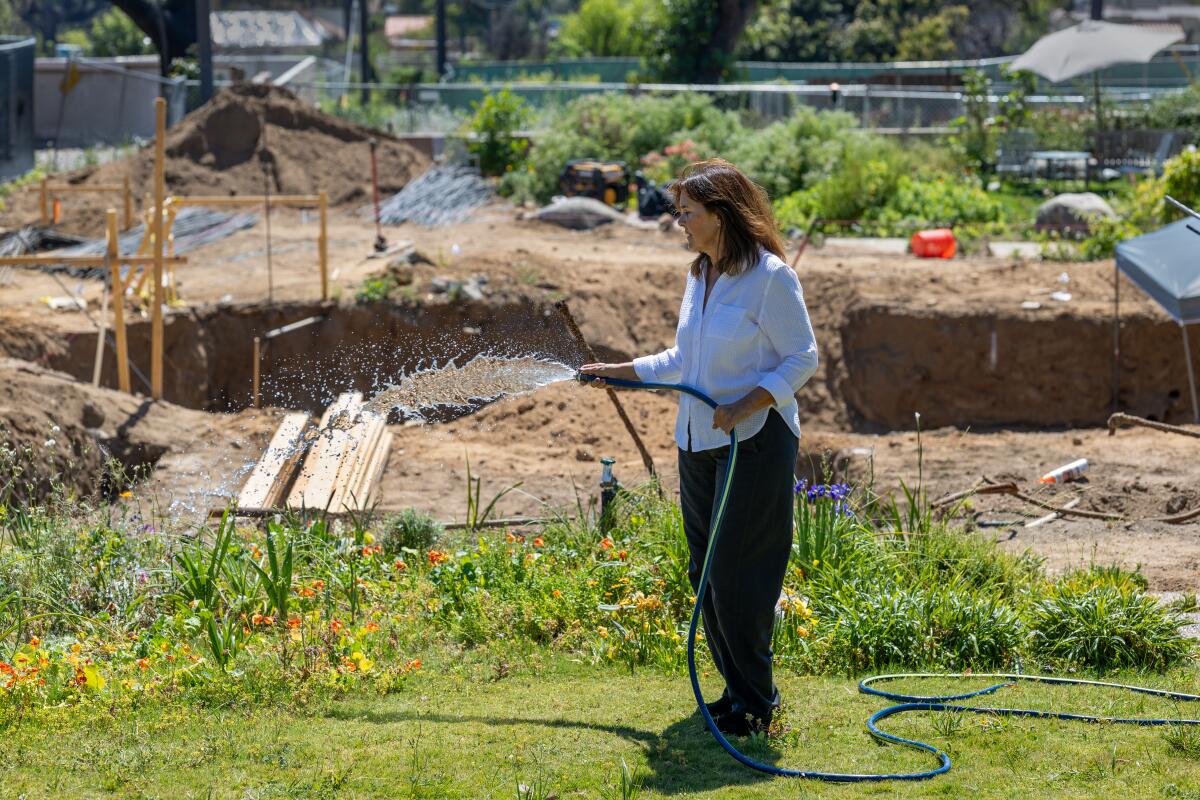 Beatriz Coca waters her garden