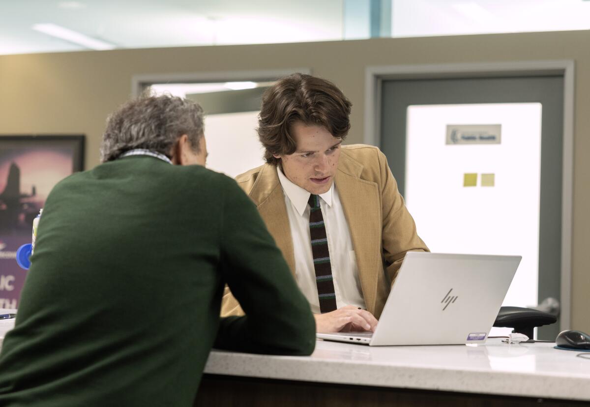 a man in a suit helps a visitor at the Los Angeles County One-Stop Center