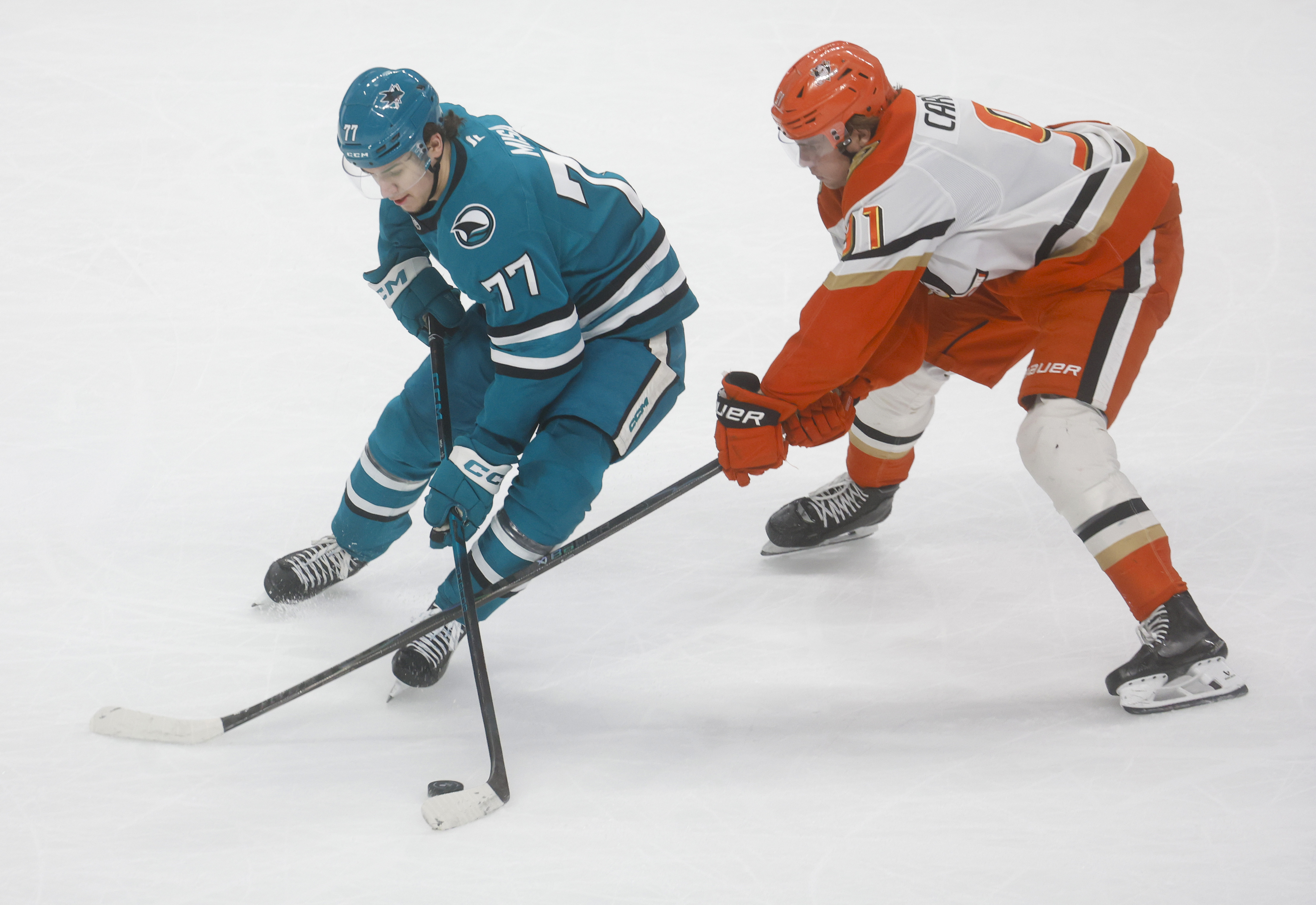 San Jose Sharks’ Michael Misa (77) controls the puck against...