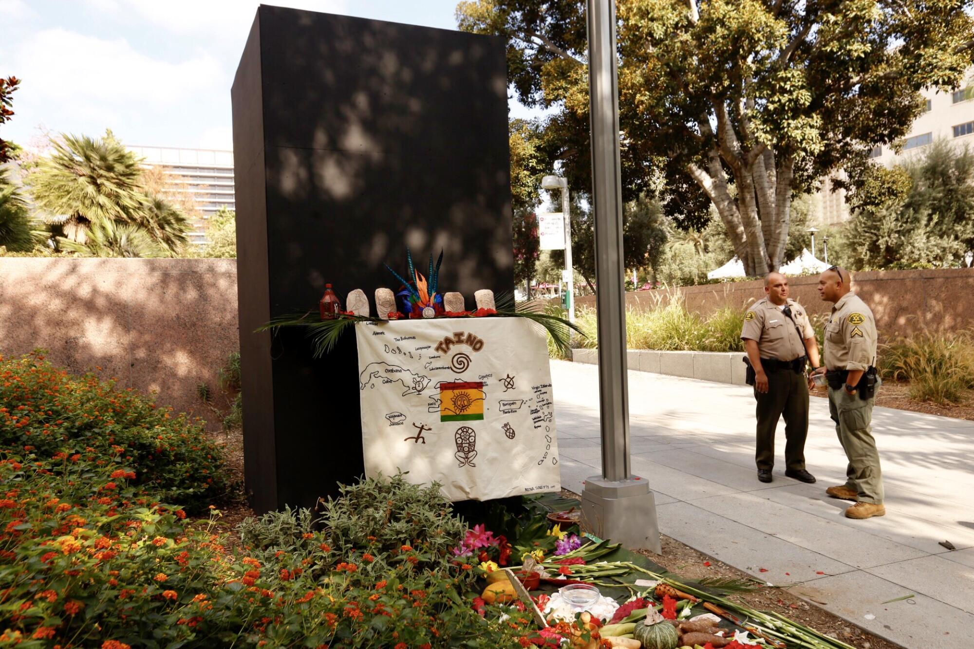 Sheriff's deputies stand next to a boxed up statue