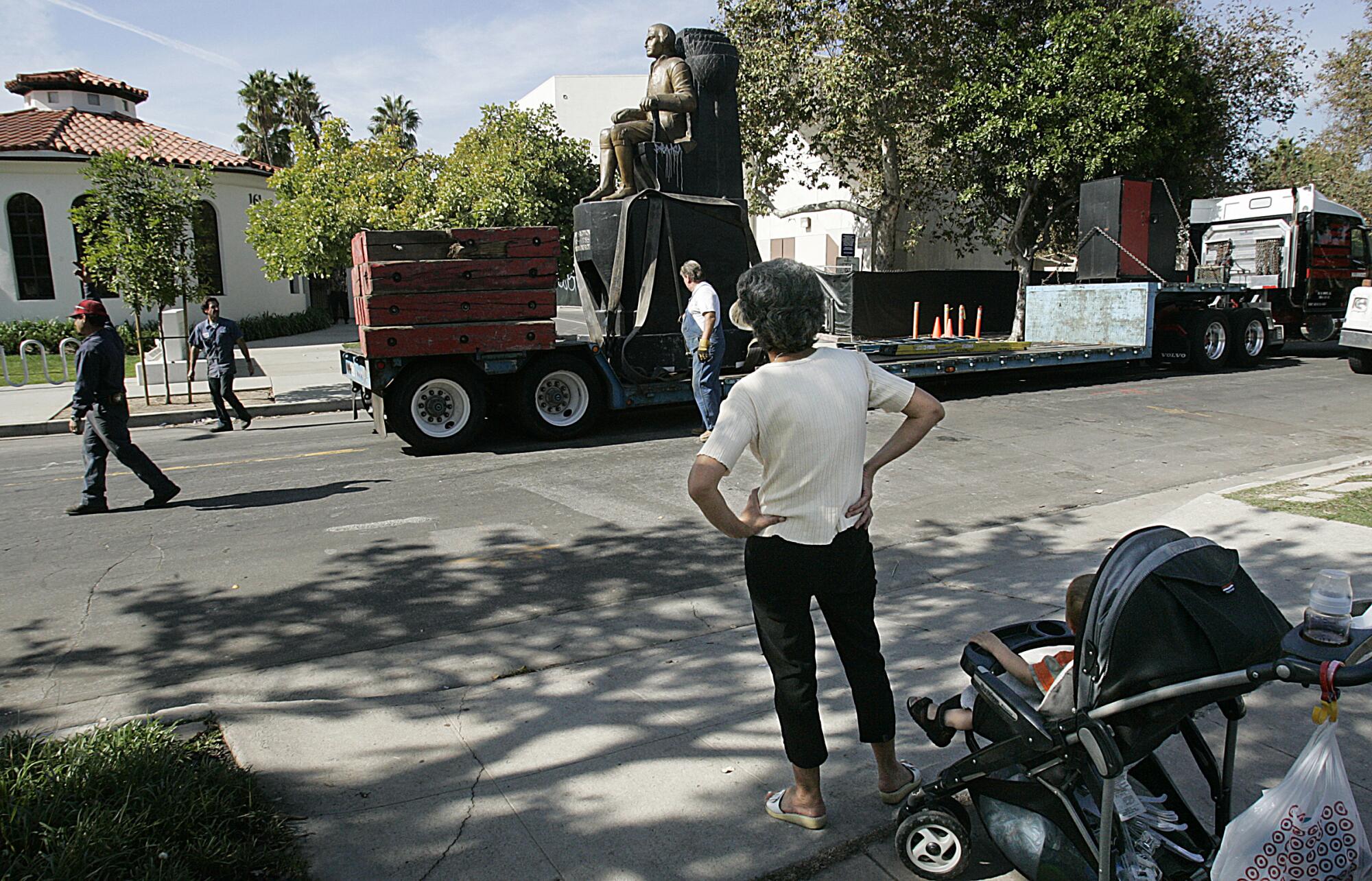 A statue of Haym Salomon is transported along a street