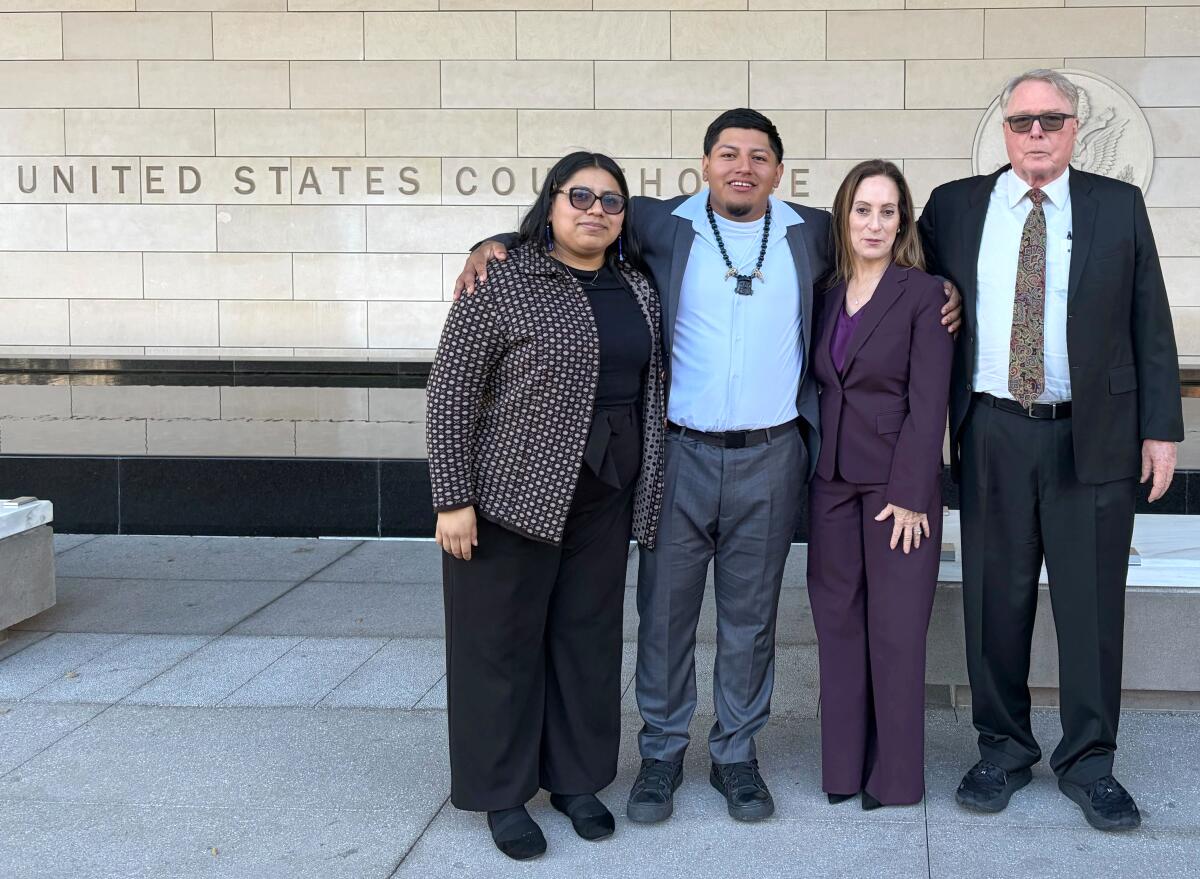 Two women and two men stand outside the downtown federal courthouse in Los Angeles.