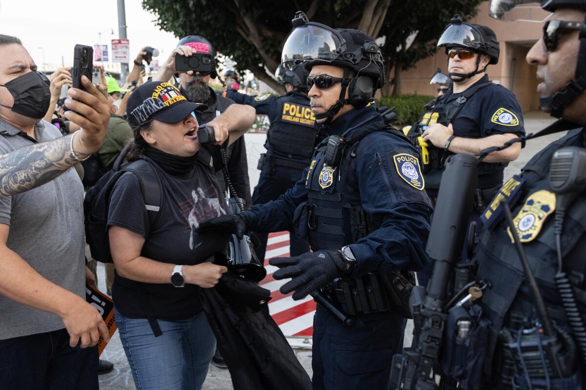 People push against police as they protest against immigration enforcement.