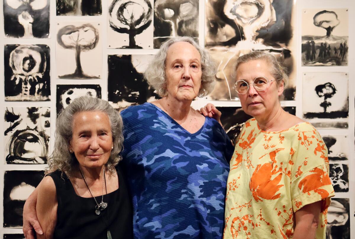 Three women in a gallery.