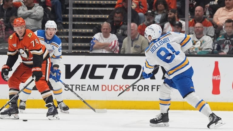 St. Louis Blues left wing Dylan Holloway, right, scores a...
