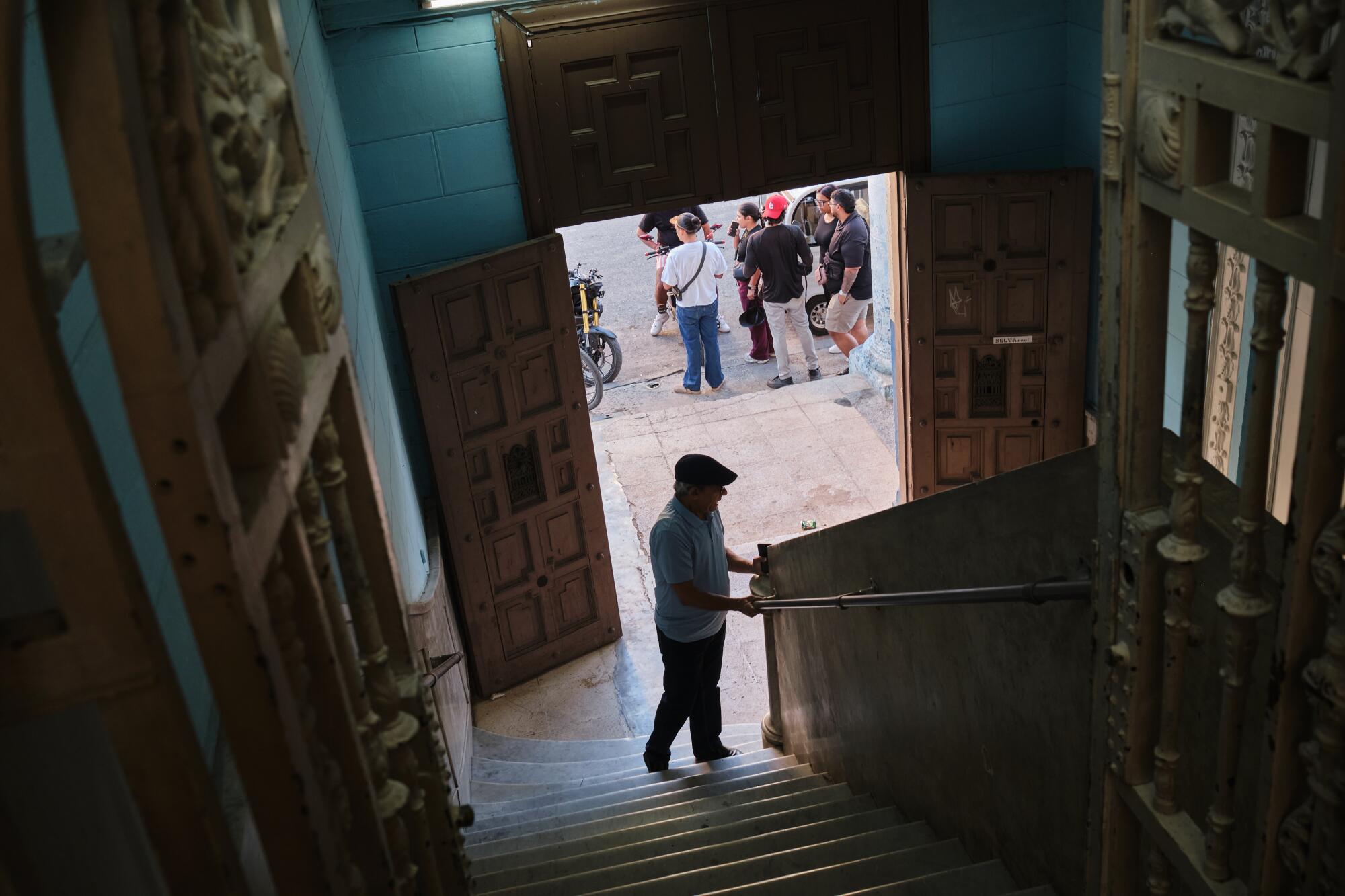 Alberto González speaks with a security worker before participants arrive at the weekly gathering