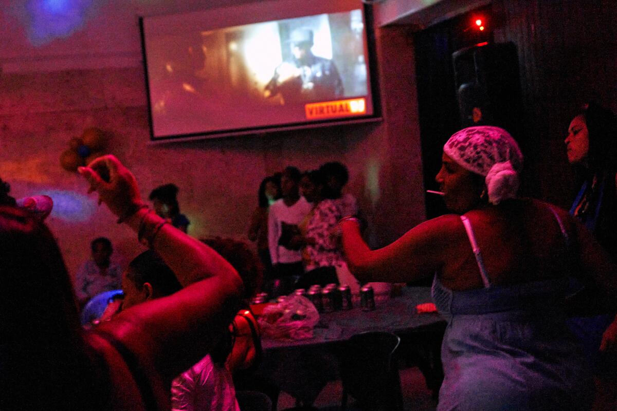 Attendees at the "Los Tradicionales" record themselves dancing while a 'reparto" song plays.