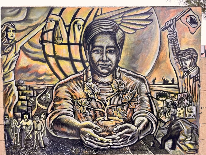 A painting shows a male presenting person holding a grape sapling.