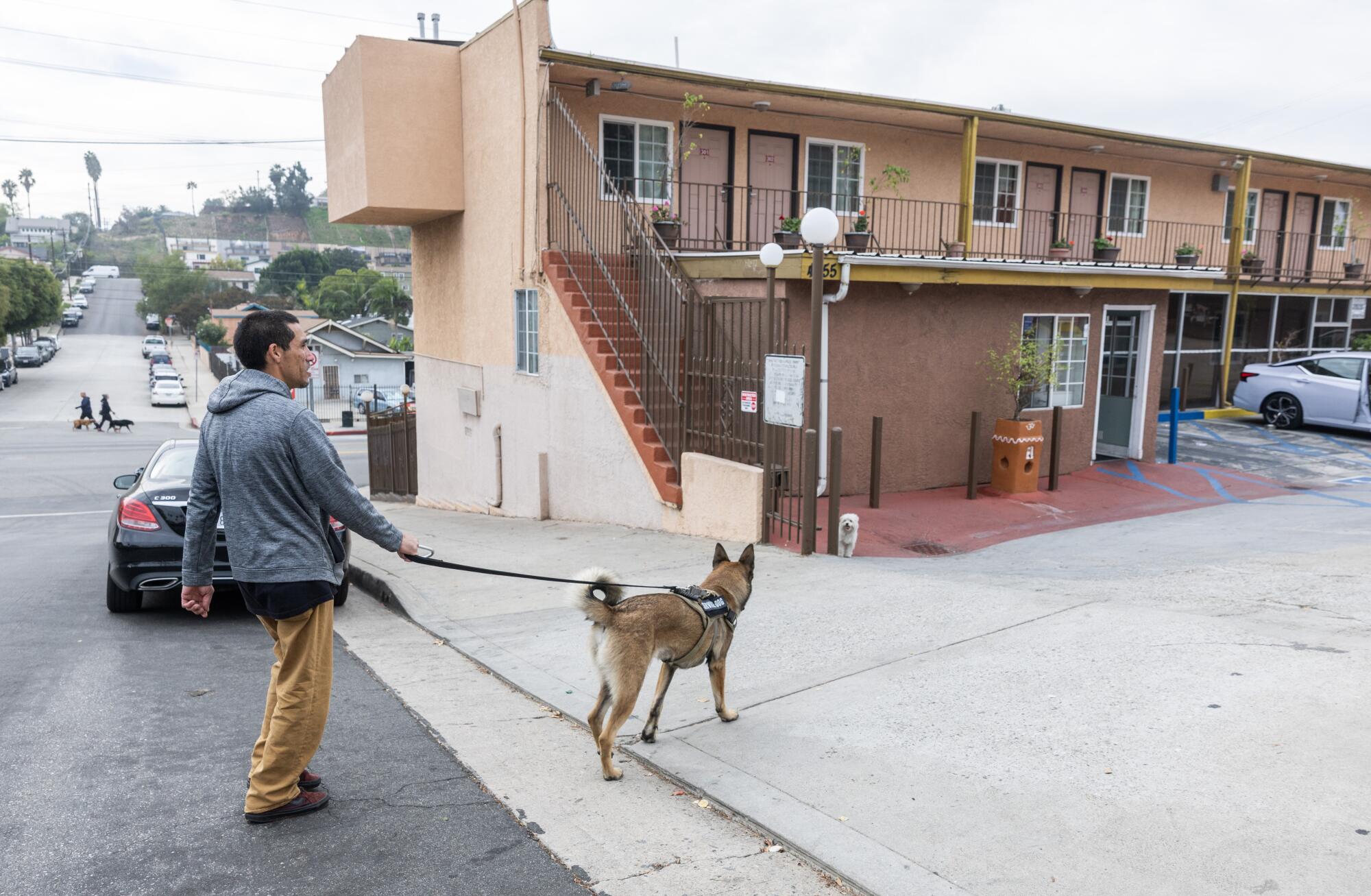Jonathan Torres walks his dog in Highland Park in November. At the time, he was living in an Inside Safe motel.