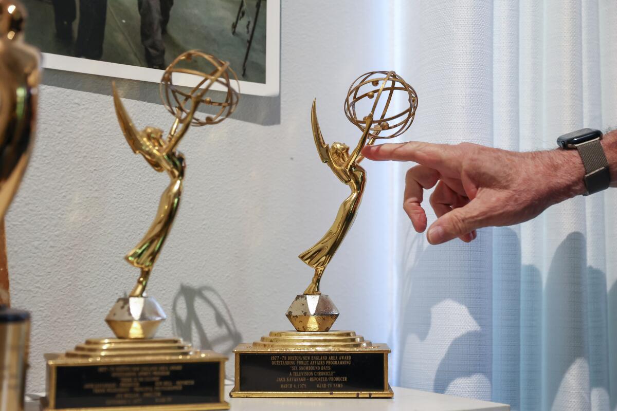 Kavanagh's finger points at two Emmys he won for television reporting