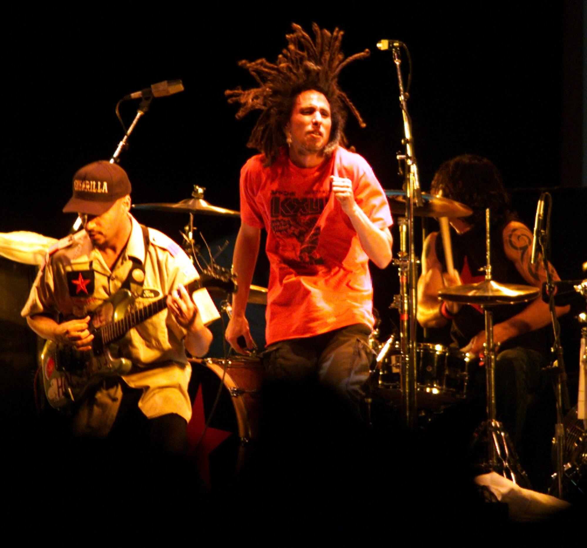 Tom Morello and Zack de la Rocha of Rage Against the Machine perform in front of a drumset