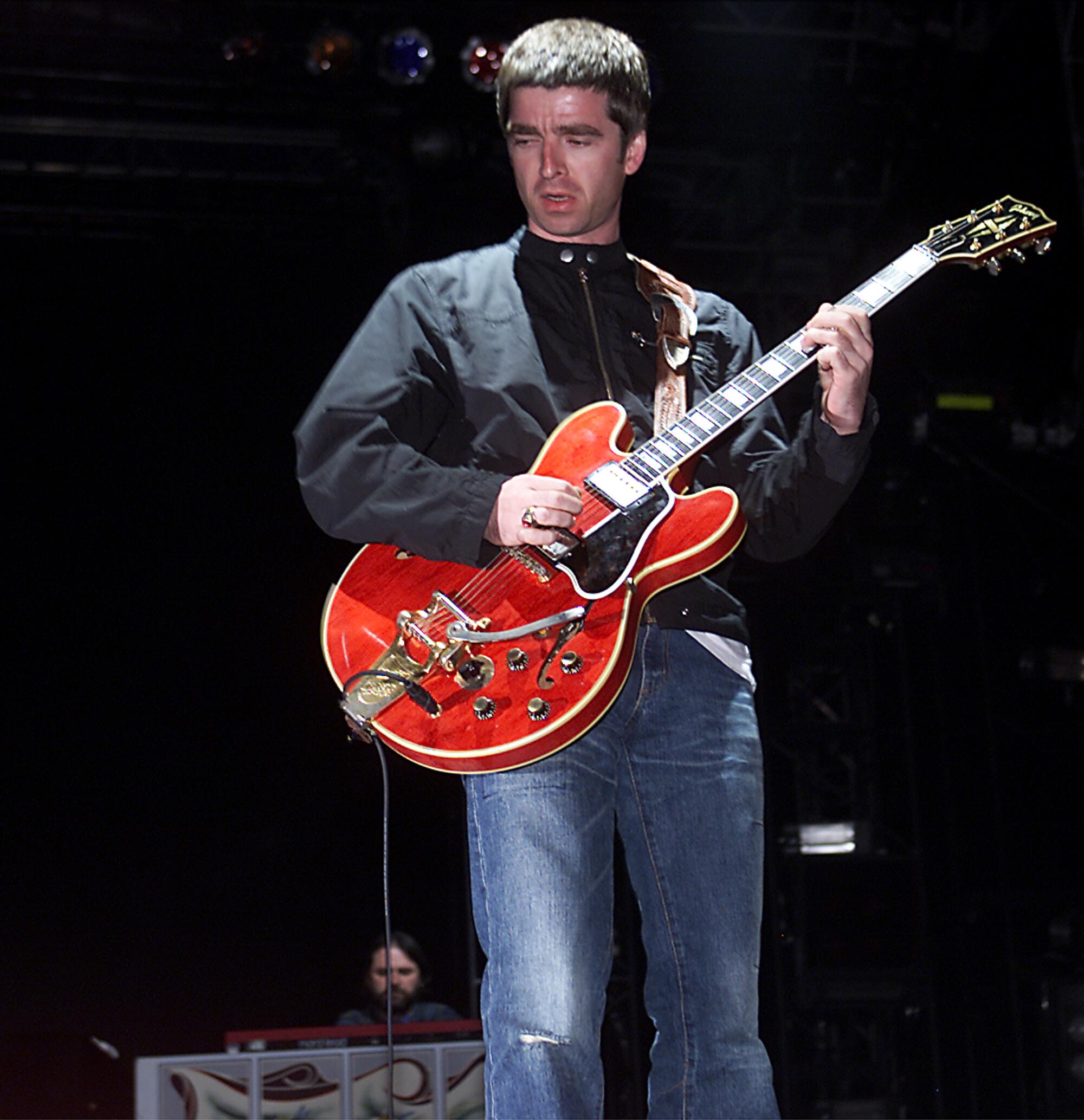 Noel Gallagher plays a red guitar