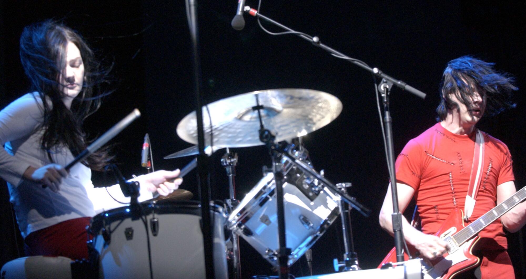 Meg White plays drums and Jack White plays guitar on a stage