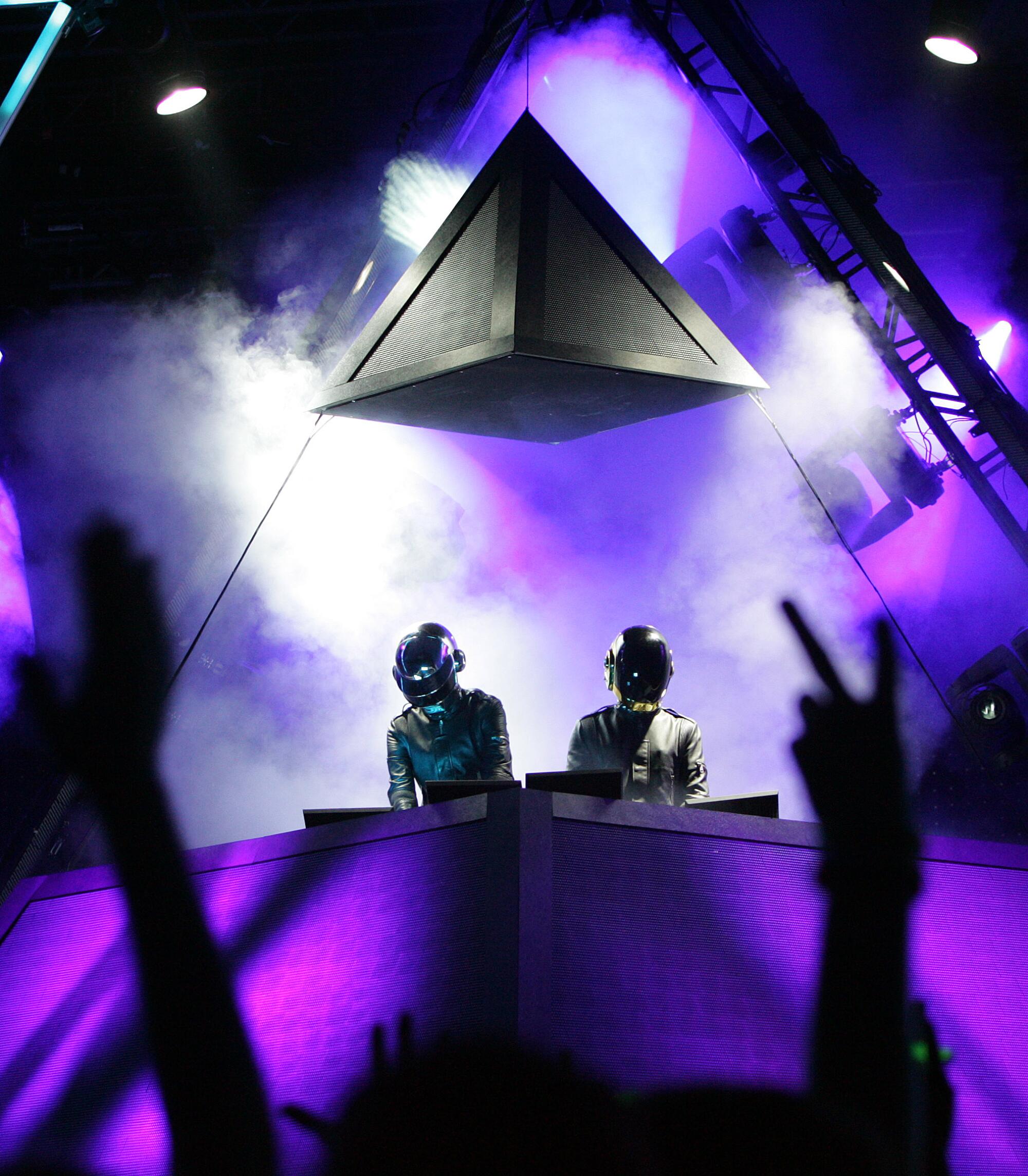 Daft Punk performs in helmets in a pyramid