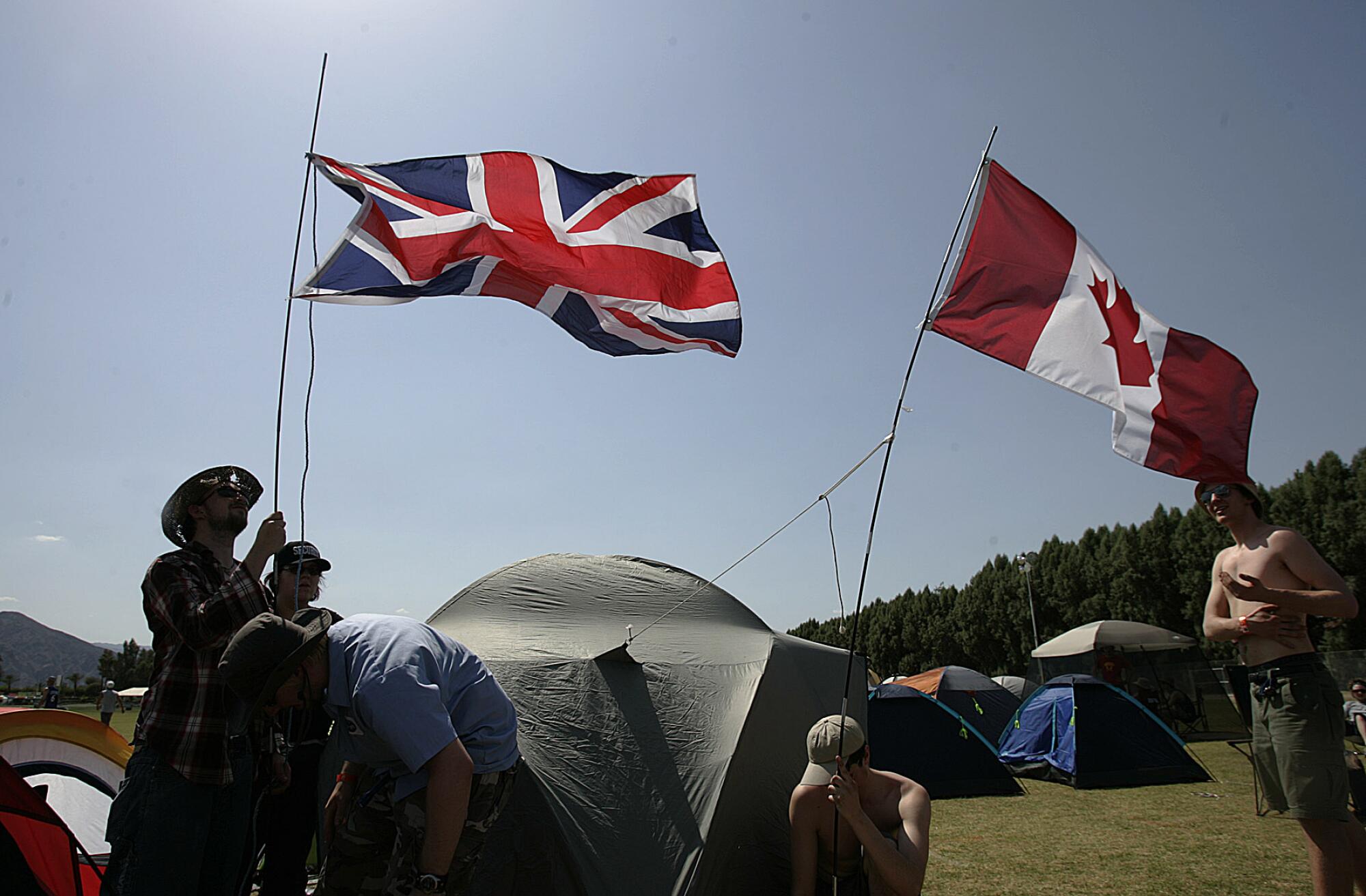British flag and a Canadian flag planted at a tent in the Coachella campground