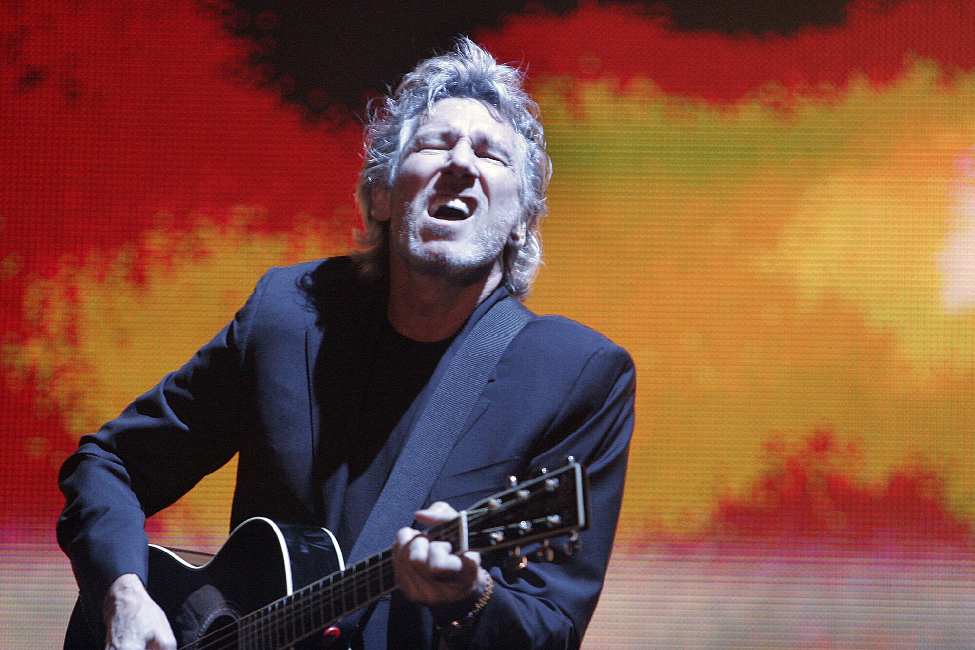 Roger Waters plays the guitar