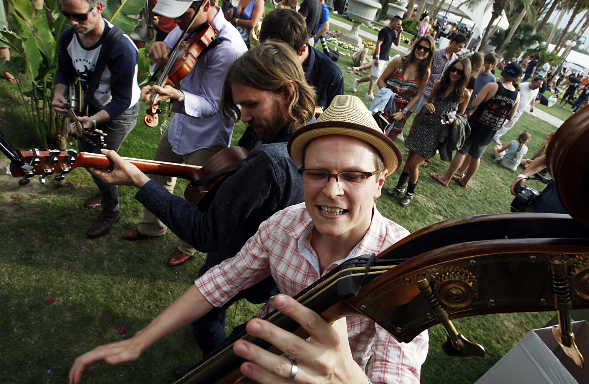 Members of the Old Crow Medicine Show jam in a grassy area