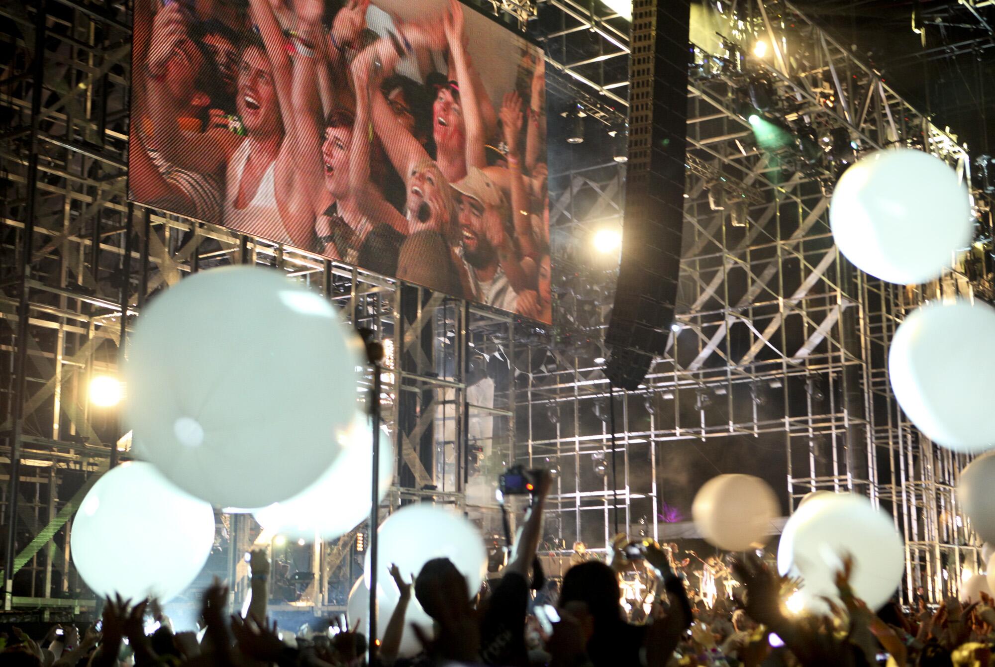 Giant LED balls bounce around the Coachella crowd while Arcade Fire plays