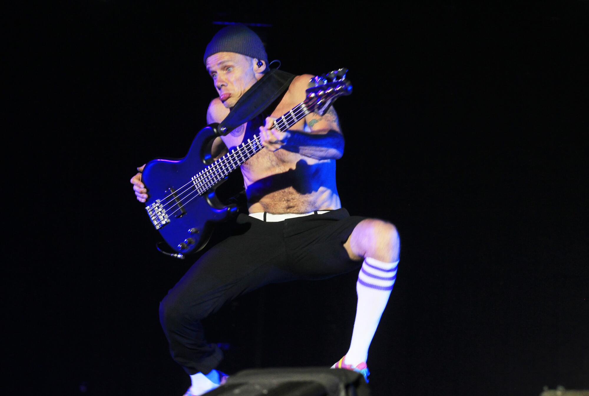 Flea of the Red Hot Chili Peppers plays the bass and pouts on stage