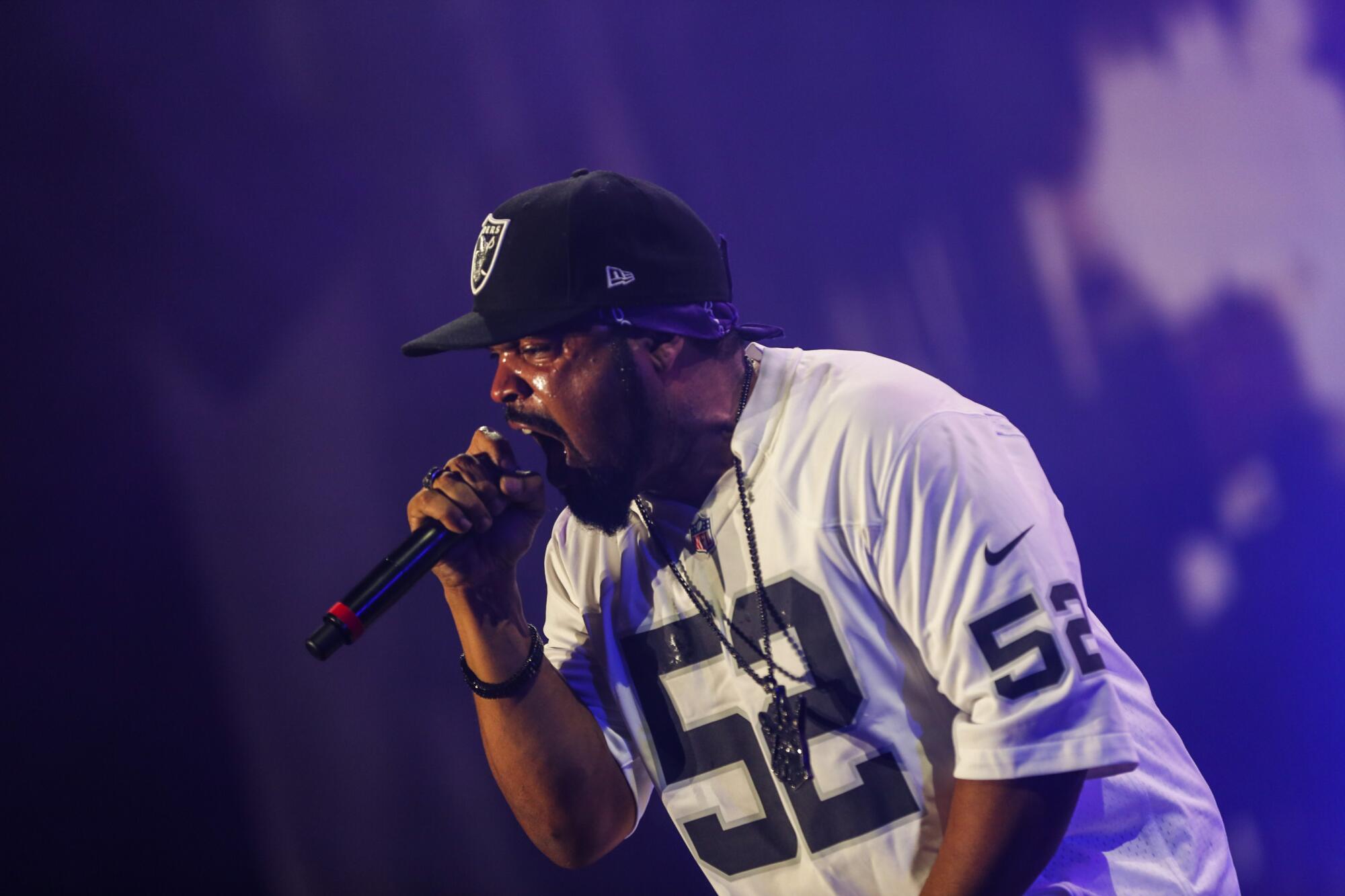 Ice Cube raps into a microphone on stage