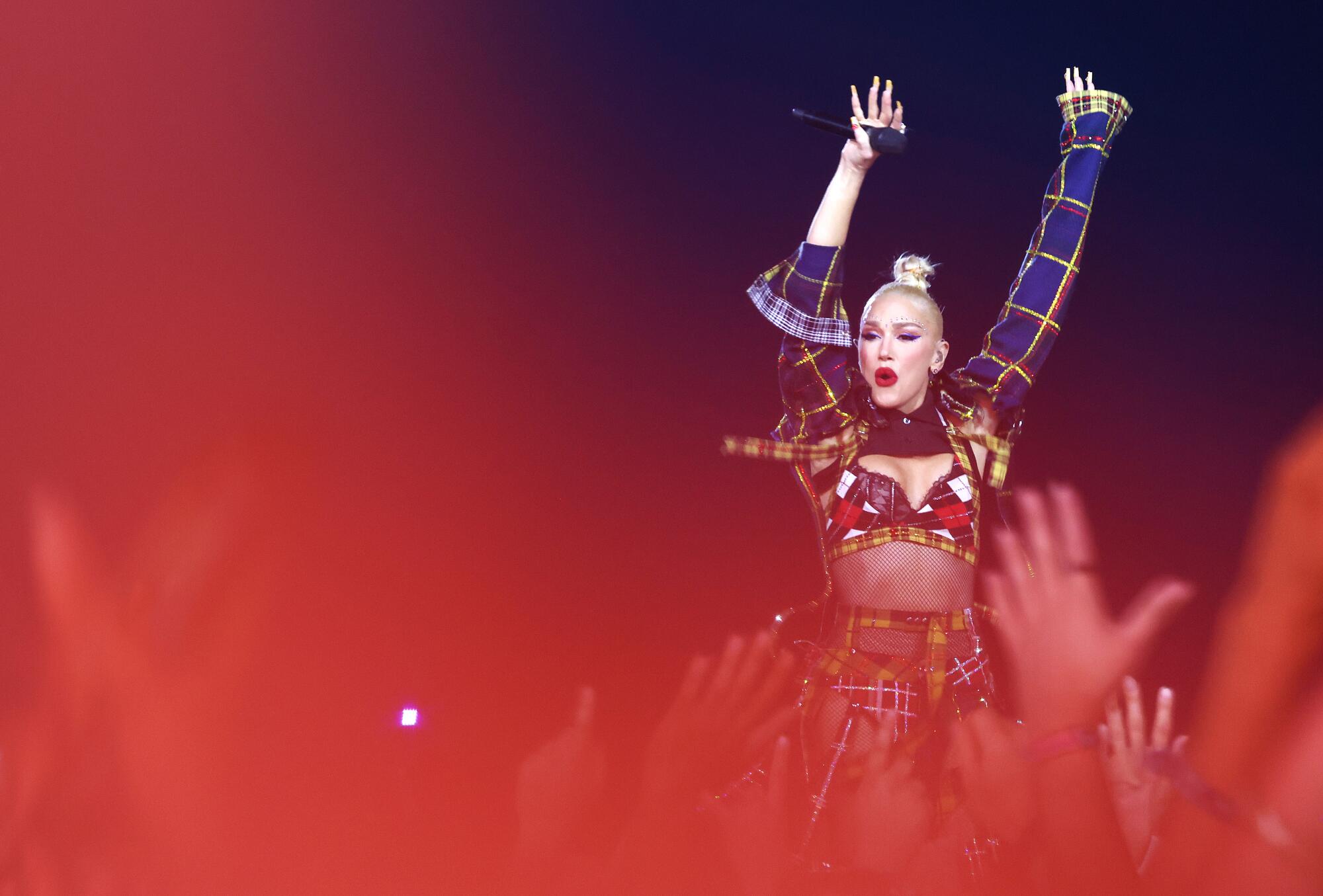 Gwen Stefani raises her hands in the air
