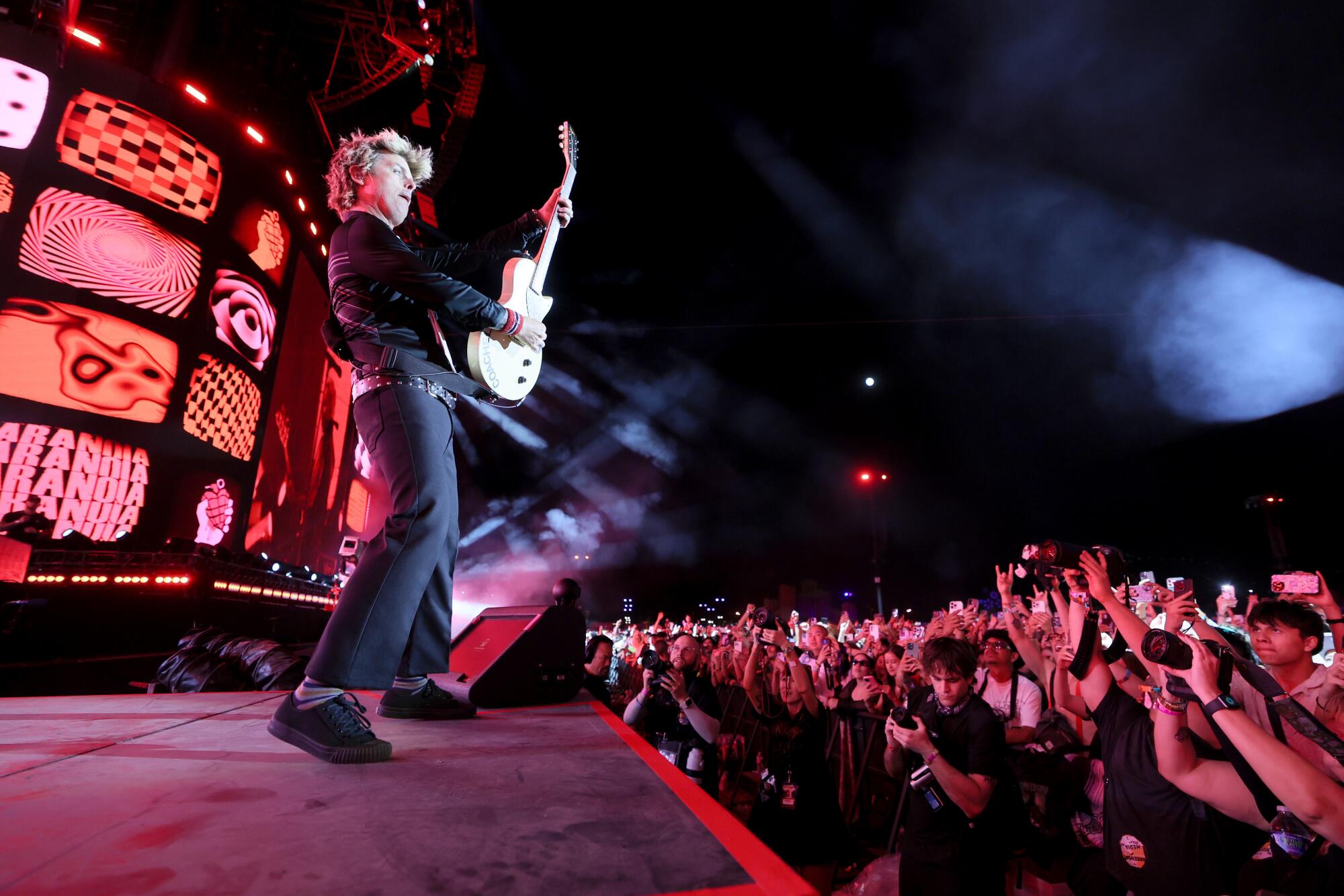 Profile shot of Billie Joe Armstrong of Green Day playing the guitar on stage