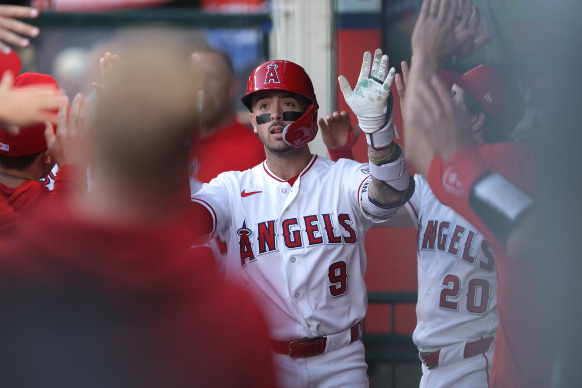 Angels star Zach Neto celebrates in the dugout after hitting a home run.