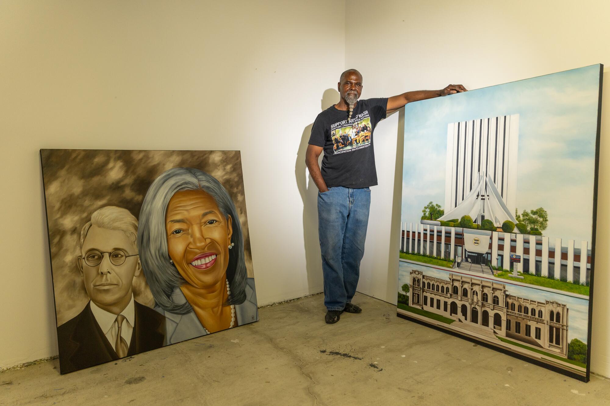 A man with two of his paintings.