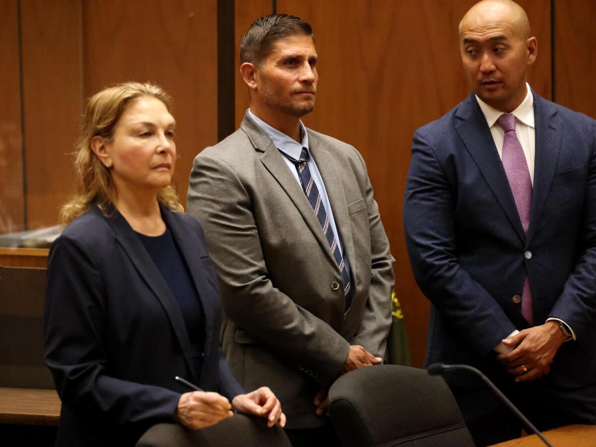 Indicted probation officer Ramses Patron, center, stands with his attorney.