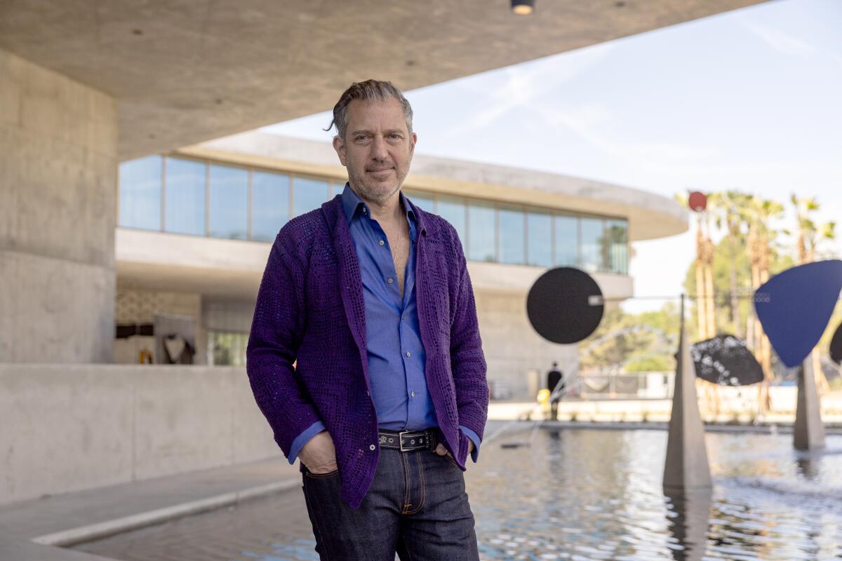 A man stands by a fountain.