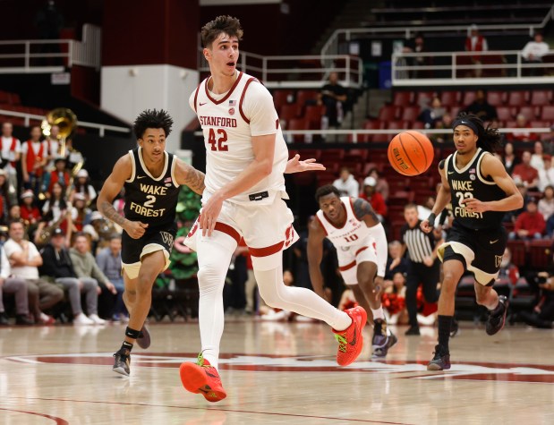 Stanford Cardinal's Maxime Raynaud (42) passes behind his back against the Wake Forest Demon Deacons in the second half at Maples Pavilion in Stanford, Calif., on Wednesday, Feb. 5, 2025. (Nhat V. Meyer/Bay Area News Group)