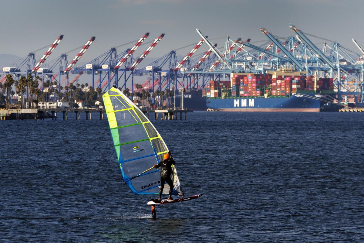 A wind foiler surfer maneuvers through the surf and wind in San Pedro.