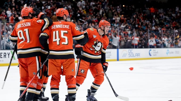Anaheim Ducks defenseman John Carlson, right, reacts with center Leo...