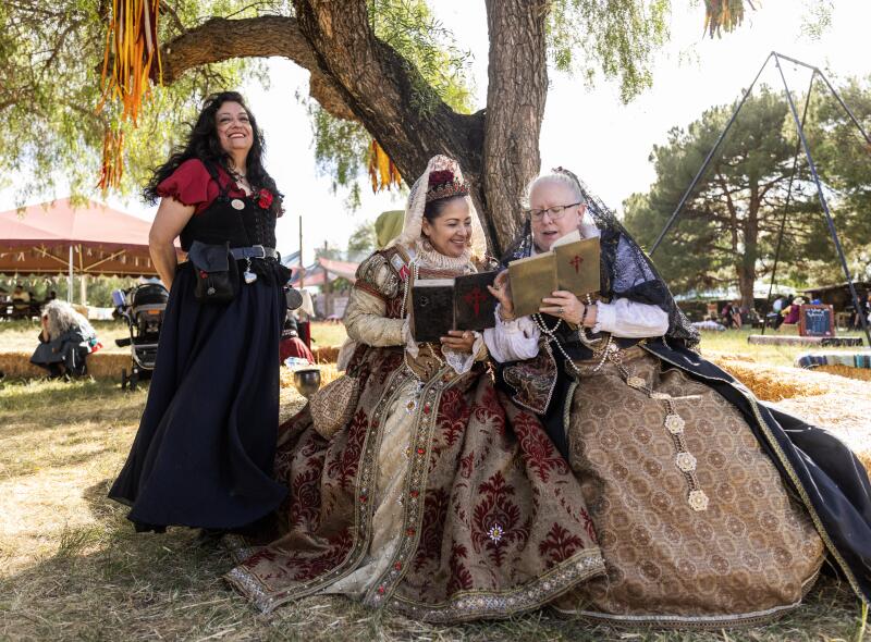 Royal guard member Maria DeSilva, left, stands by Anna of Austria, the queen of Spain, and her sister Elisabeth of Austria as they read their Bibles together.