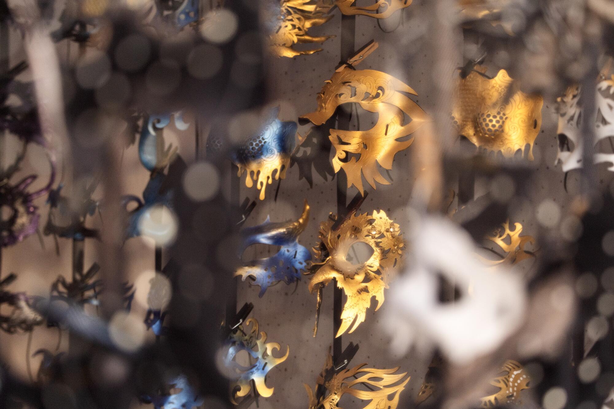 Gold and blue-gold masquerade masks shimmer in the light