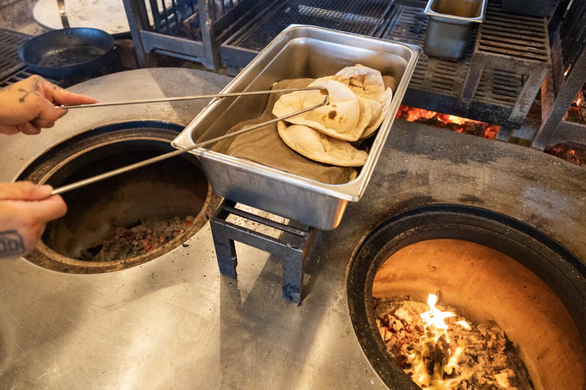 LOS ANGELES, CA - APRIL 01 2026: Tone bread cooked in a wood-fired oven is ready to be served at Maydan Restaurant